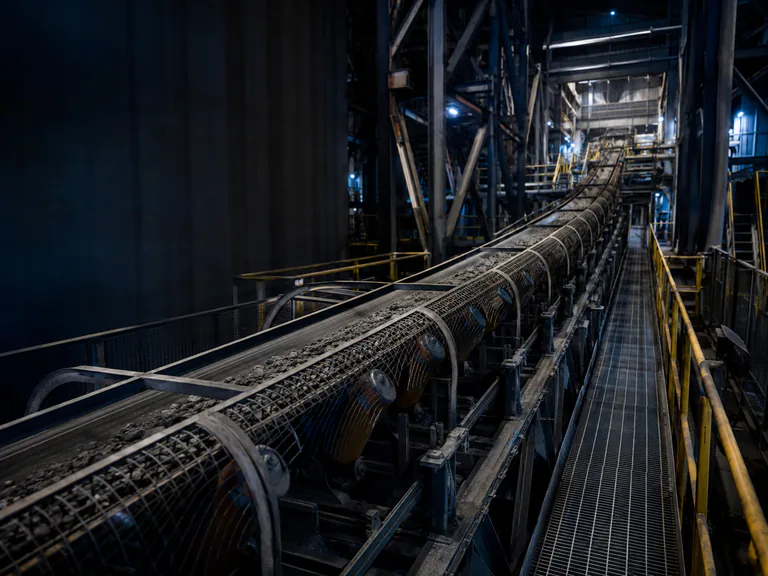 Heavy industrial ore conveyor and guarded walkway